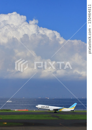 一架客機起飛上升。一架Air Do飛機飛向夏天的天空。 一架客機起飛上升。一架Air Do飛機飛向夏天的天空。 130464811