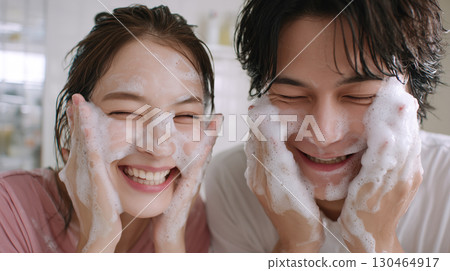 Young couple enjoying foam face wash in their home bathroom | Smiling couple, skincare, bathroom photo 130464917