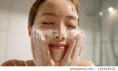 Relaxing self-care shot of a woman washing her face with foam in her bathroom at home Relaxing self-care shot of a woman washing her face with foam in her bathroom at home 130464918