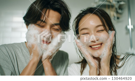 Couple enjoying foam face wash in the bathroom | Skin care and smiling shots in the bathroom at home 130464920