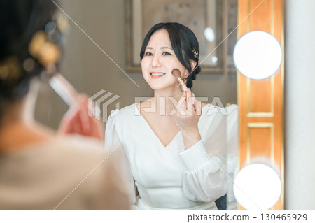 新娘在婚禮場地的新娘房化妝 新娘在婚禮場地的新娘房化妝 130465929