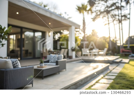 Cozy Outdoor Space with Comfortable Furniture and Lush Greenery at Sunset in a Modern Residence 130466293