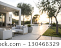 Modern outdoor living space with lounge furniture and tranquil sunset view in the background Modern outdoor living space with lounge furniture and tranquil sunset view in the background 130466329
