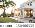 Elegant Modern Home Exterior with Sunlight and Green Landscape in Soft Focus at Sunset Elegant Modern Home Exterior with Sunlight and Green Landscape in Soft Focus at Sunset 130466335