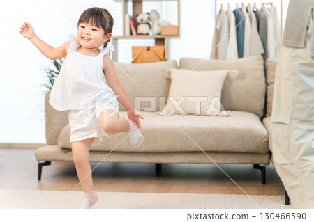 A tomboyish girl dancing in the living room of her own home A tomboyish girl dancing in the living room of her own home 130466590