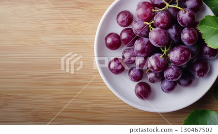 Grapes purple fruit in white ceramic bowl in copy space wooden table 130467502
