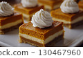 Pumpkin cheese bar slice with vanilla sweet cream topping layered white cream 130467960