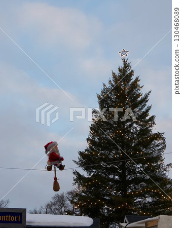 Christmas tree and Santa Claus doll moving through the sky 130468089