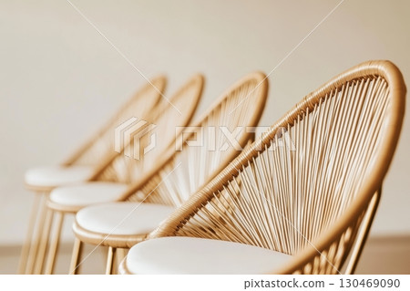 Stylish rattan chairs arranged in a modern interior setting during daylight hours 130469090