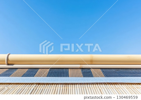 Traditional bamboo structure contrasting with a clear blue sky during midday in a tranquil outdoor setting Traditional bamboo structure contrasting with a clear blue sky during midday in a tranquil outdoor setting 130469559