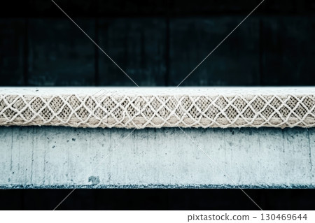 Artistic close-up of a textured rope placed on a concrete surface showcasing unique patterns during daylight 130469644