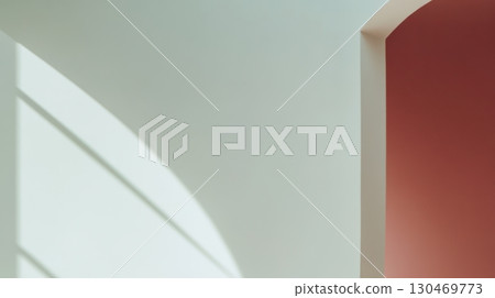 Natural light casts soft shadows on minimalist architecture in a softly colored interior space 130469773