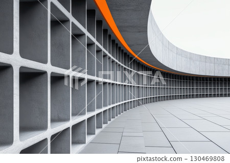 A contemporary architectural feature displays a smooth, curved concrete wall designed with textured square blocks 130469808