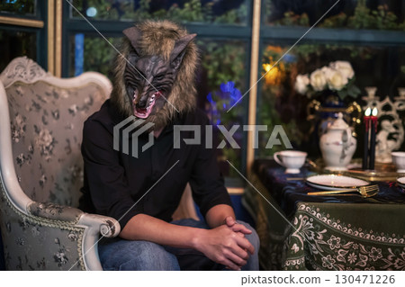 man with werewolf mask at dinner table for 2025 Halloween party man with werewolf mask at dinner table for 2025 Halloween party 130471226