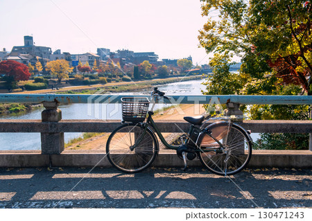Bicycle on bridge across Kamo River with autumn maple leaf, Kyoto 130471243