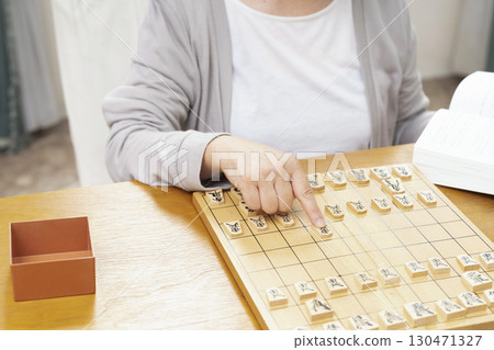 一位老年婦女獨自練習將棋愛好的手 130471327