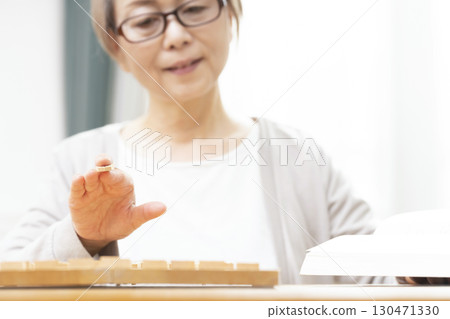 一位老年婦女獨自練習將棋愛好的手 130471330