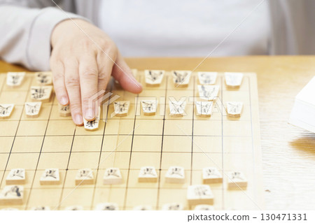 一位老年婦女獨自練習將棋愛好的手 130471331