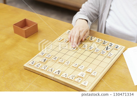 The hands of a senior woman practicing her hobby of shogi alone 130471334
