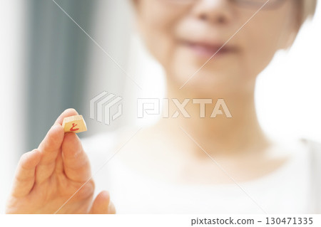 一位老年婦女獨自練習將棋愛好的手 一位老年婦女獨自練習將棋愛好的手 130471335