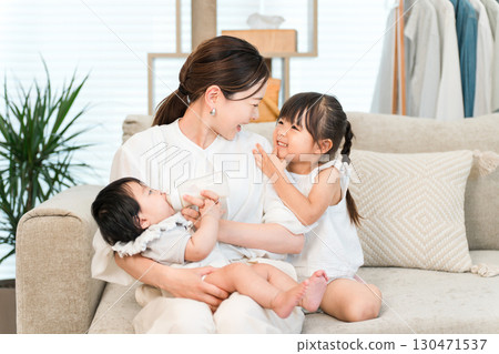 母親抱著嬰兒在沙發上,媽媽(育兒,全職家庭主婦) 母親抱著嬰兒在沙發上,媽媽(育兒,全職家庭主婦) 130471537