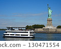 The Statue of Liberty and a sightseeing boat on a clear day 130471554