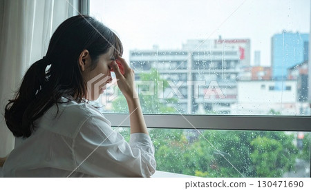 A woman on a rainy day with her eyes closed sadly 130471690