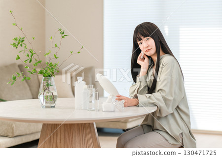 A woman who takes care of her skin to keep it moisturized (worries, worries, problems, skin troubles, complexes) 130471725