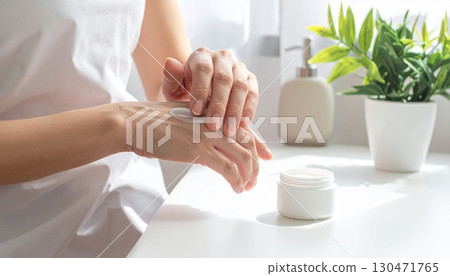 Image of moisturizing care spreading over white hands 130471765