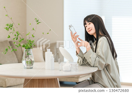 一位年輕的亞洲女性使用基本化妝品來保濕、護膚和抗衰老。 一位年輕的亞洲女性使用基本化妝品來保濕、護膚和抗衰老。 130472680