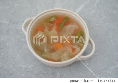 Vegetable Soup in White Bowl on a Gray Surface 130473143