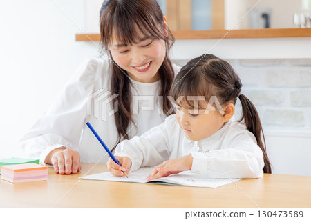 一個女孩和她的母親在客廳學習 130473589