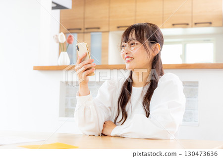 A woman watching a smartphone A woman watching a smartphone 130473636