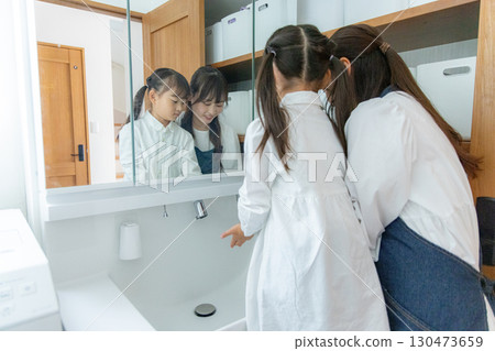 Parent and child washing hands in the washroom 130473659