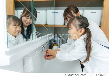 Parent and child washing hands in the washroom 130473663