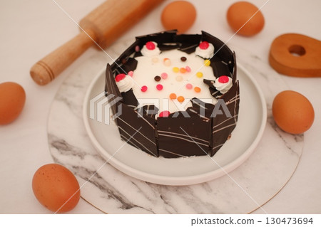 Delicious Chocolate Cake with White Frosting and Colorful Sprinkles 130473694