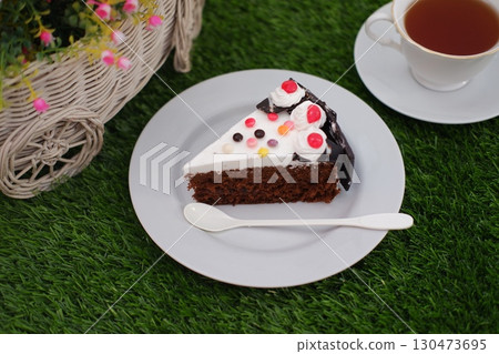 Delicious Slice of Cake on a Plate with Tea Delicious Slice of Cake on a Plate with Tea 130473695