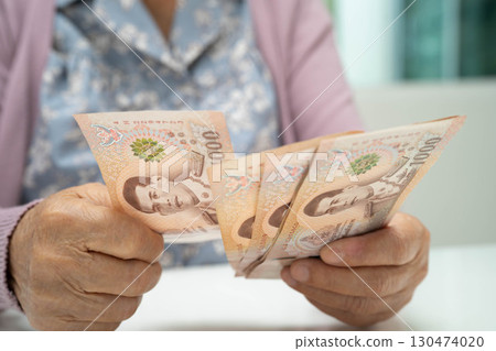 Retired elderly woman counting coins money and worry about monthly expenses and treatment fee payment. 130474020