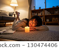 Relaxation time for women enjoying the aroma candle night while lying down 130474406