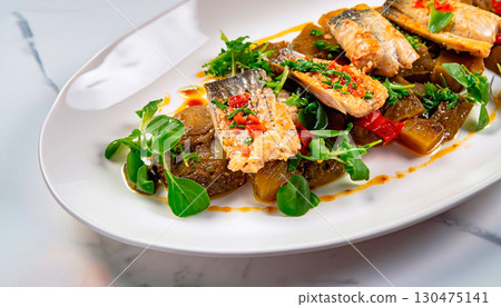 The Bacalau garnished with greens in a plate on a white marble serving table The Bacalau garnished with greens in a plate on a white marble serving table 130475141