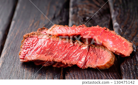 The macro photo of boiled red beef meat on a black wooden surface 130475142