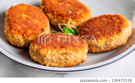 photo of Kiev-style cutlet in a plate on a white marble servery table 130475538