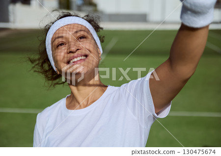 Smiling Female Tennis Player at Court Sunny Atmosphere Smiling Female Tennis Player at Court Sunny Atmosphere 130475674