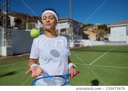 Woman Practicing Tennis Skills on an Outdoor Sunny Day Court Woman Practicing Tennis Skills on an Outdoor Sunny Day Court 130475676