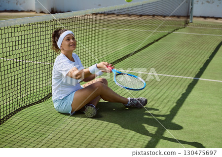 Smiling Tennis Player Sitting On Court After Match 130475697