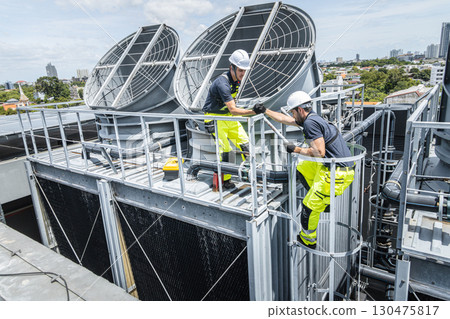 Professional worker servicing HVAC building cooling tower, Industry air conditioner service 130475817