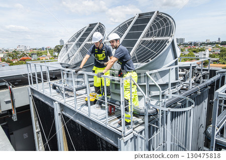 Professional worker servicing HVAC building cooling tower, Industry air conditioner service 130475818