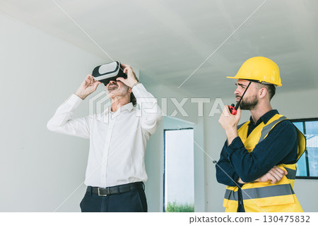 Construction project manager using VR visual modern technology device with engineer builder at site Construction project manager using VR visual modern technology device with engineer builder at site 130475832