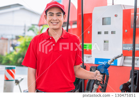 Happy gas station staff worker hand holding fuel nozzle for refill car fuel, Petroleum business 130475851