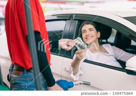 Gas station staff worker receiving cash money for fuel bill payment, Petroleum business Gas station staff worker receiving cash money for fuel bill payment, Petroleum business 130475864